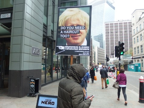 Advertising placard seen on Fenchurch Street using Boris Johnson's unruly mop to advertise a local barber's shop