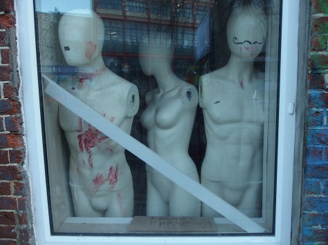 Shop dummies in the window with a found purse message below them